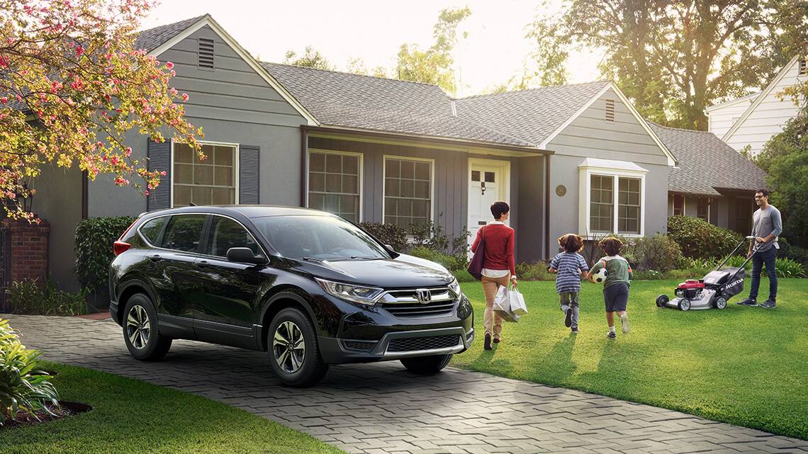 Side profile view of 2019 Honda CR-V Touring in Dark Olive Metallic with Honda Genuine Accessory short roof box and crossbars.