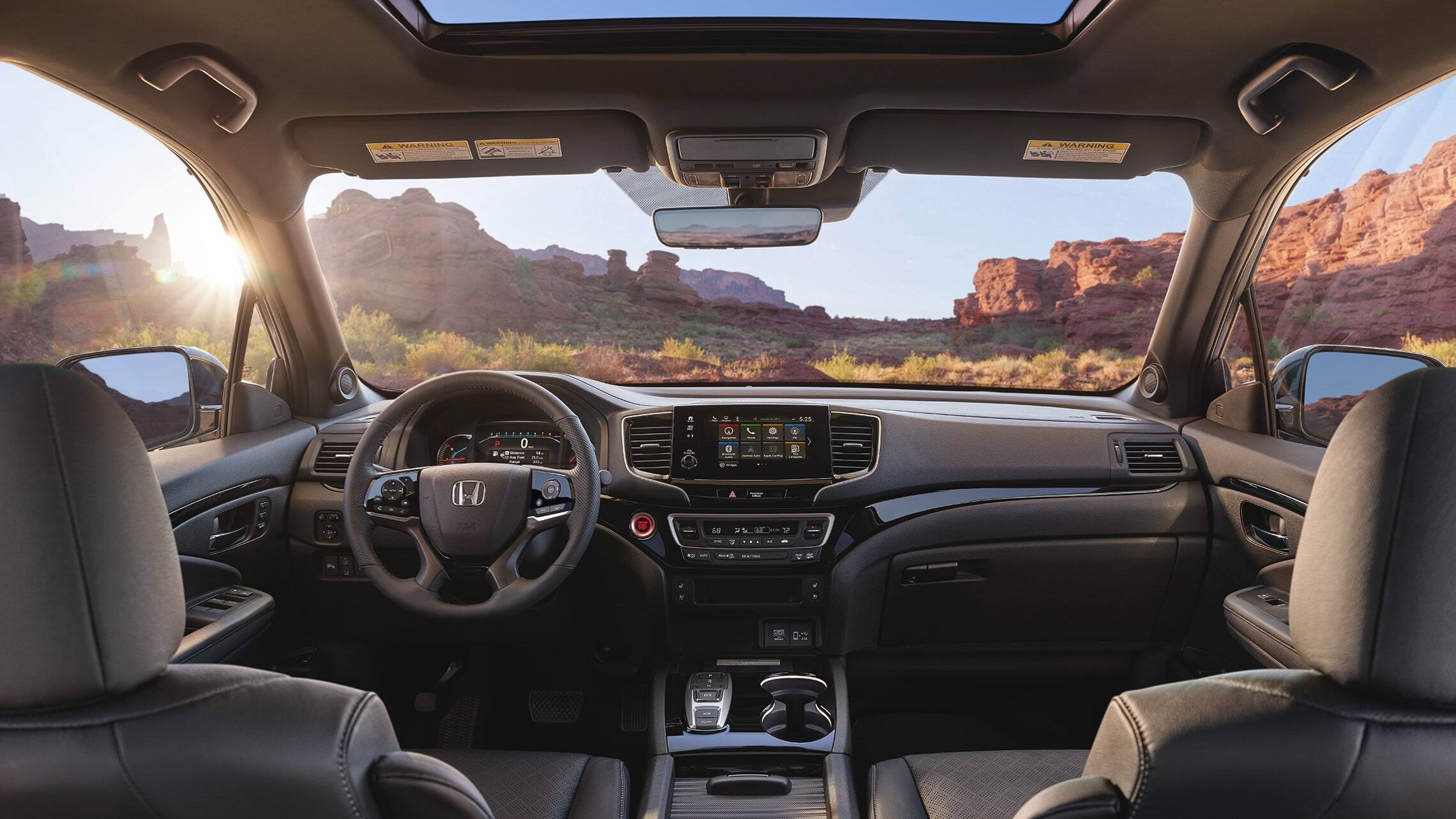 2019 Honda Passport Elite interior view with Black Leather interior showing the major instrument panel, featuring Apple CarPlay™ integration on the Display Audio touch-screen.