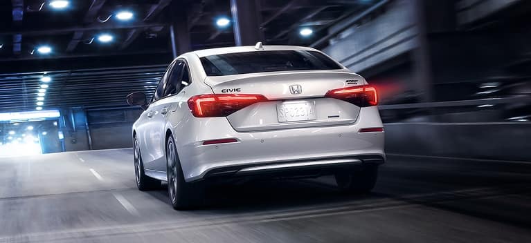2027 Honda Civic Sedan Sport Touring Hybrid in Platinum White Pearl white rear view driving through tunnel (Compact Sedan)